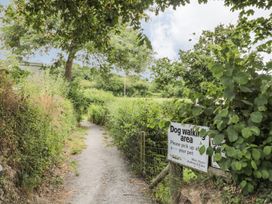 A path with a dog walking area sign at Maple Lodge Teigngrace near Kingsteignton