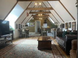 A living room with a tv, sofa, and dining area at Queensbury Loft in Par