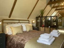 A bedroom with a bed and towels on a table at Queensbury Loft in Par