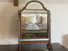 A mirror reflecting a bed with pillows and towels at Queensbury Loft in Par