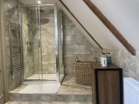 A bathroom with a shower and storage unit at Queensbury Loft in Par
