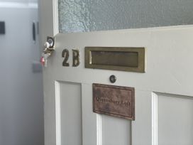 An entrance door with a nameplate at Queensbury Loft in Par