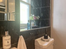 A bathroom with a mirror, toilet, and a window at DeCressy Apartment in Par