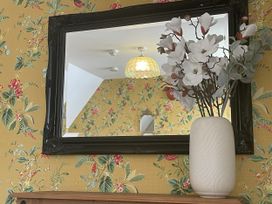 A living room with a mirror and flower vase at DeCressy Apartment in Par