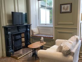 A living room with a fireplace and television at Garden Apartment in Par