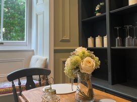 A dining room with table and flowers at Garden Apartment in Par