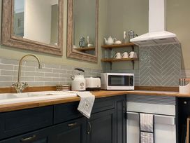 A kitchen with sink microwave and kettle at Garden Apartment in Par