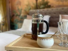 A tray with a French press and cups in a bedroom at Garden Apartment in Par