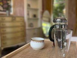 A coffee setup with a french press and cups at Garden Apartment in Par