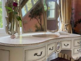 A vanity table with a flower vase at Garden Apartment in Par