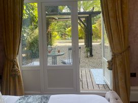 A view of a garden from a bedroom with a table and chairs at Garden Apartment in Par