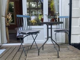 An outdoor seating area with a table and chairs at Garden Apartment in Par