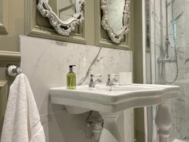 A sink with a mirror and soap dispenser in the bathroom at Garden Apartment in Par
