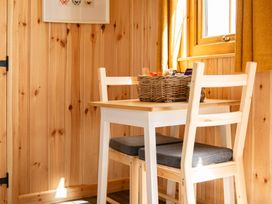 A dining area with a table and chairs at Head For the Hills Glamping - Skylark Shepherd's Hut