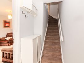 A hallway with a staircase and storage cabinet at 1 Windermere in Kinvarra