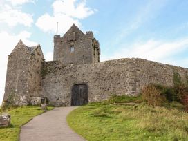 A castle with a stone wall and pathway at 1 Windermere in Kinvarra