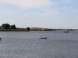 A boat on a body of water with land and trees in the background at 1 Windermere Kinvara, County Galway