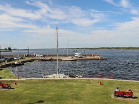 A view of a harbor with boats and people sitting on benches at 1 Windermere in Kinvara, County Galway