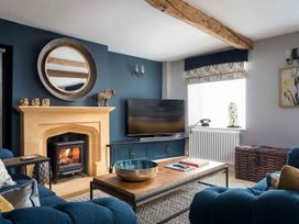 A living room with a fireplace and television at Lavender Cottage (Stow-on-the-Wold) Cheltenham
