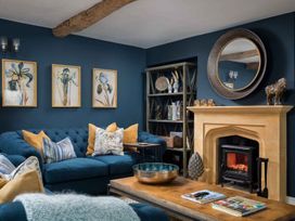 A living room with a blue sofa and fireplace at Lavender Cottage (Stow-on-the-Wold) Cheltenham