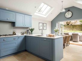 A kitchen with cabinets, stove, and countertop at Lavender Cottage (Stow-on-the-Wold) Cheltenham