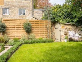 A garden with a wooden fence, shed, plants, and a bench at Lavender Cottage (Stow-on-the-Wold) Cheltenham