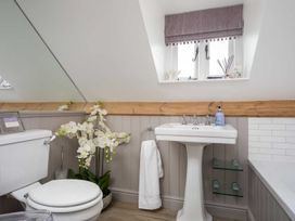 A bathroom with a toilet, washbasin, and window at Lavender Cottage (Stow-on-the-Wold) Cheltenham