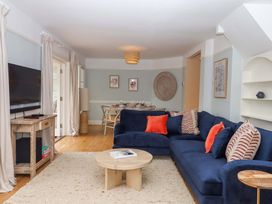 A living room with a sofa and television at The Porthole in Newton Ferrers
