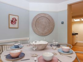 A dining room with a table set for meals at The Porthole in Newton Ferrers