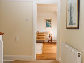 A hallway with a door leading to a room with furniture at The Porthole in Newton Ferrers