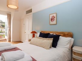 A bedroom with a bed and a lamp at The Porthole in Newton Ferrers