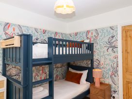 A bedroom with a bunk bed and nightstand at The Porthole in Newton Ferrers
