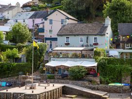 An outdoor view of a restaurant building with a patio and decorations at The Porthole in Newton Ferrers