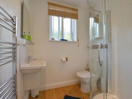 A bathroom with a shower, sink, and toilet at The Porthole in Newton Ferrers