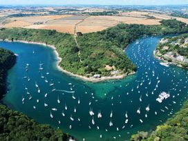 An aerial view of boats in water with surrounding greenery at The Porthole in Newton Ferrers