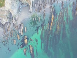 An aerial view of rocks and sandy beach at The Porthole in Newton Ferrers
