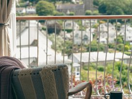 A balcony with a chair and a mug at The Porthole in Newton Ferrers