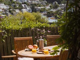 An outdoor dining area with a wooden table and chairs at The Porthole in Newton Ferrers
