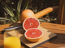 A cutting board with halved grapefruit and a glass of juice at The Porthole in Newton Ferrers