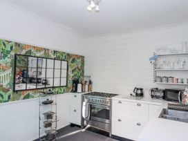 A kitchen with a stove, sink, and mirrored wall at 26 Above Town in Dartmouth