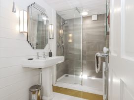 A bathroom featuring a sink, shower, and mirror at 26 Above Town in Dartmouth