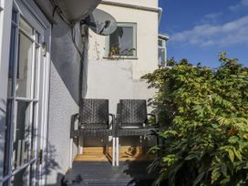 A balcony with two chairs and plants at 26 Above Town in Dartmouth
