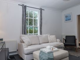 A living room with a sofa, window, and a table at 26 Above Town in Dartmouth