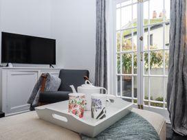 A living room with a television, sofa, and tea set at 26 Above Town, Dartmouth