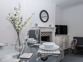 A dining room with a table set and a television in the background at 26 Above Town in Dartmouth
