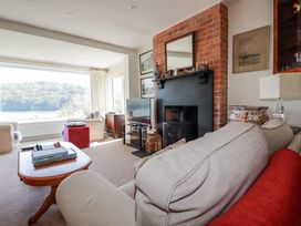 A living room with a fireplace and television at Kiln Cottage in Golant near Tywardreath