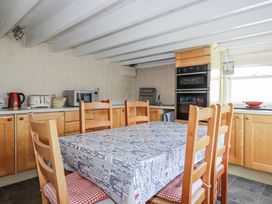 A kitchen with a table and chairs at Kiln Cottage Golant near Tywardreath