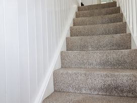 A staircase with carpet and white walls at Kiln Cottage Golant near Tywardreath