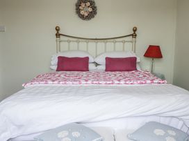 A bedroom with a bed and lamp at Kiln Cottage Golant near Tywardreath