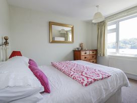 A bedroom with a bed and dresser at Kiln Cottage in Golant near Tywardreath